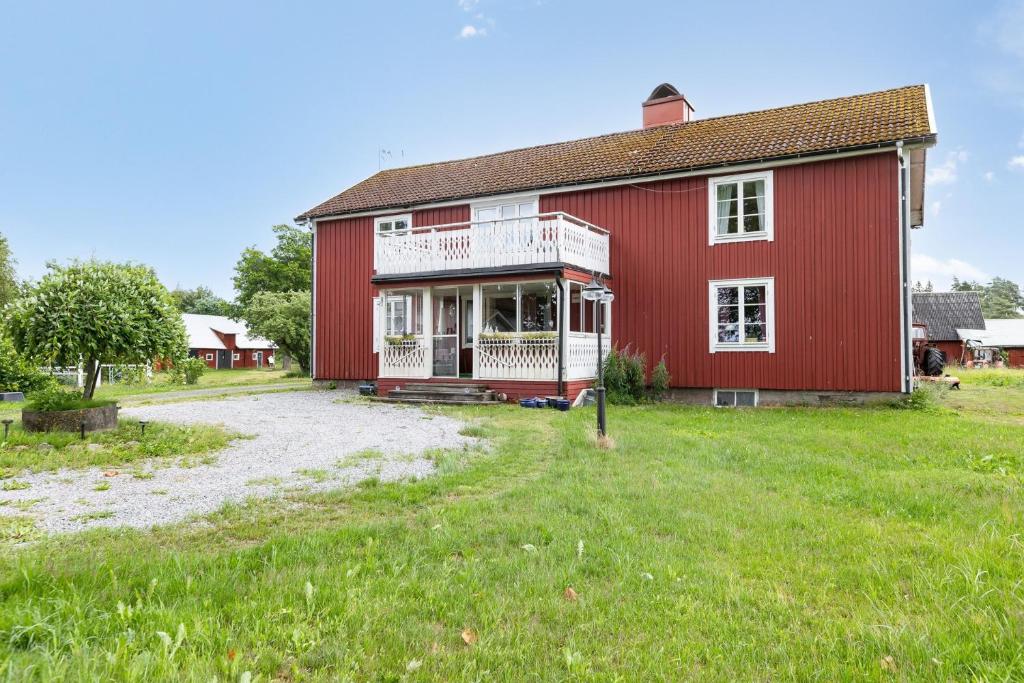 RyssbyHoliday house with central location 17 km from Ljungby的一间红色的房子,设有白色门廊和庭院
