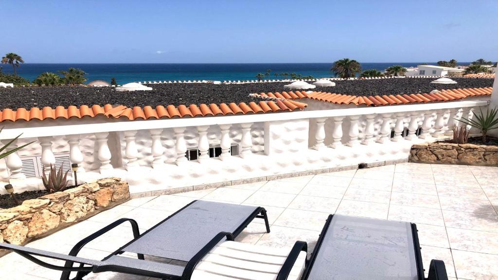 科斯塔卡玛Top Seaside Powered by SolymarCalma的一个带椅子的庭院和背景海洋