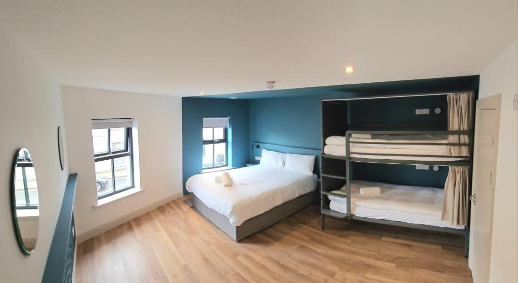 巴利纳Heyday Hostel Ballina的一间卧室配有一张床和一张双层床。