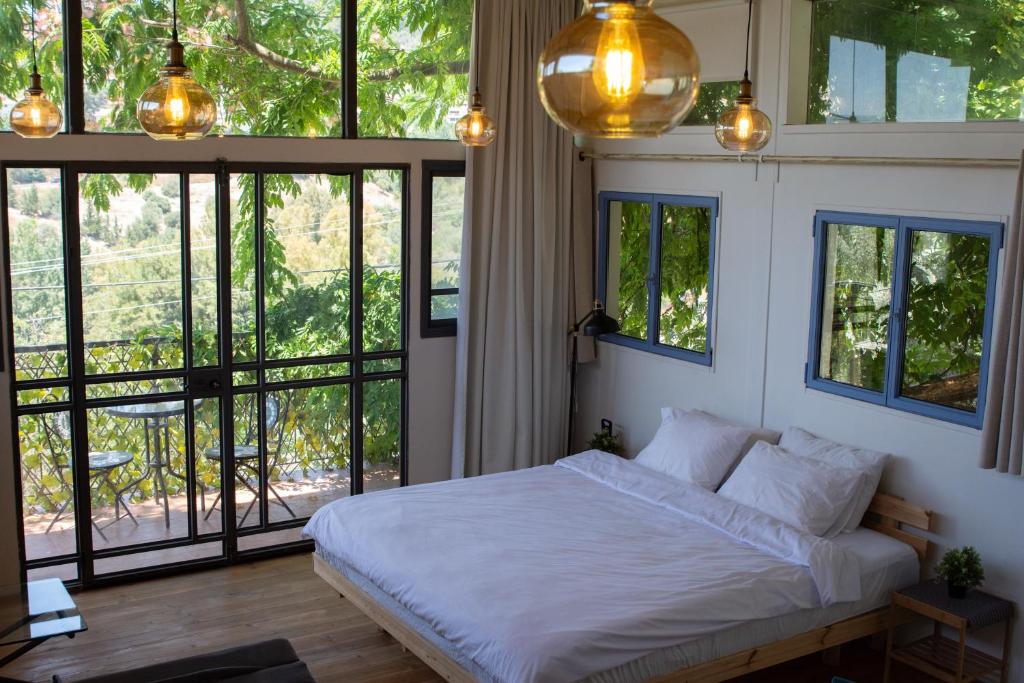 萨法德Harmony Inn的一间卧室配有一张带白色床单和窗户的床。