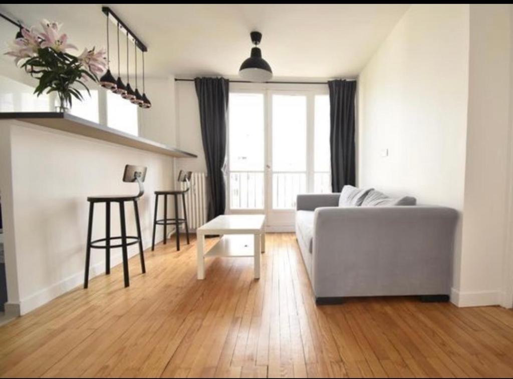 奥贝维利埃Superbe appartement cosy Paris/Stade de France的客厅配有沙发和桌子