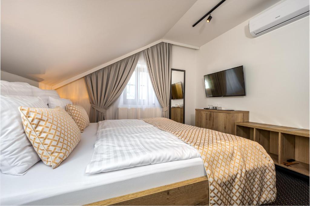 捷克克鲁姆洛夫Penzion Golden Crown的一间卧室配有一张大床和电视