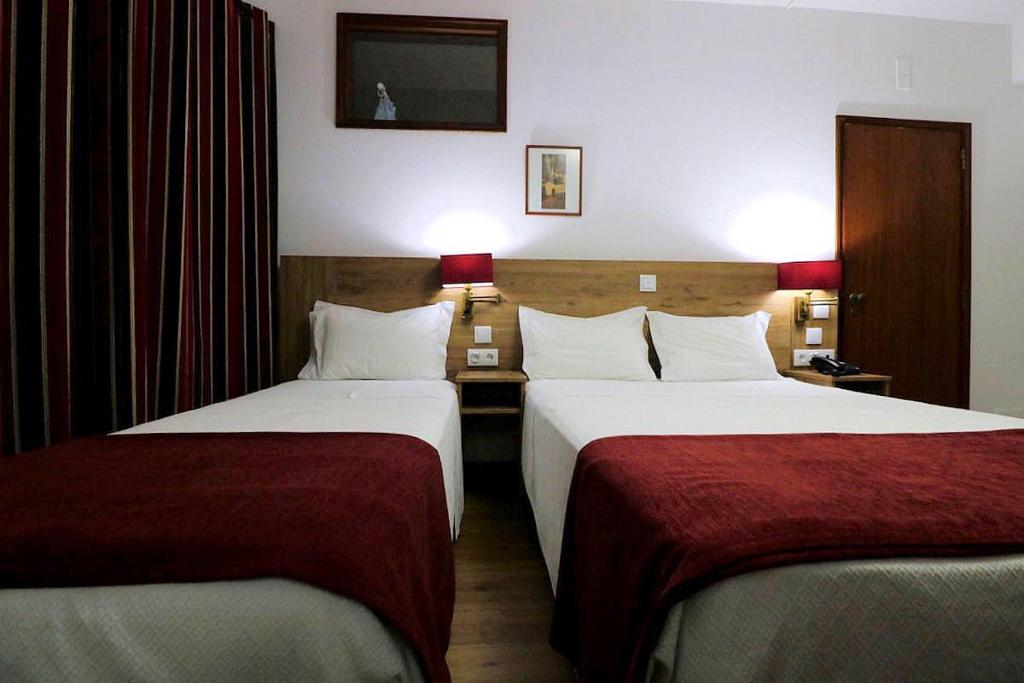 菲盖罗杜什维纽什罗塔马奥酒店的酒店客房,配有两张带红色床单的床