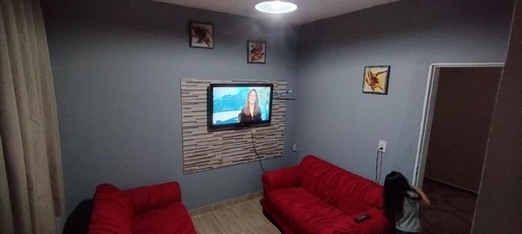 乌贝拉巴Casa de Boneca aconchegante的客厅配有红色沙发和平面电视