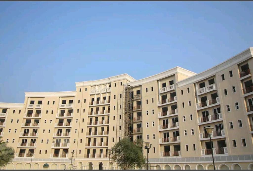 范兰德凡Ac Beautiful Luxury stay in Omaxe Vrindavan Jai bankebihariji by Shishamare的一座大公寓楼,后面是蓝色的天空