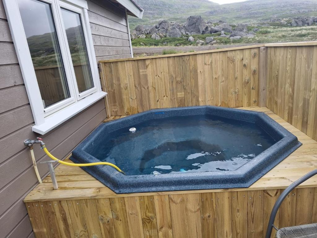 Hvammur 6 with private hot tub的房屋甲板上的按摩浴缸