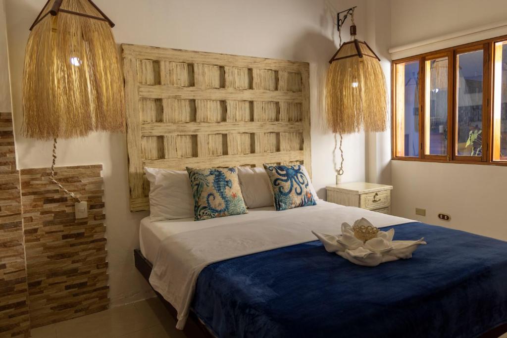 巴克里索莫雷诺港Galapagos Planet Hotel的一间卧室配有一张大床和木制床头板