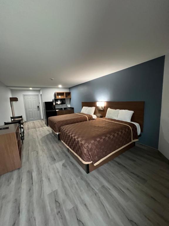钱诺夫Relax Inn Channelview的酒店客房配有两张床和一张书桌