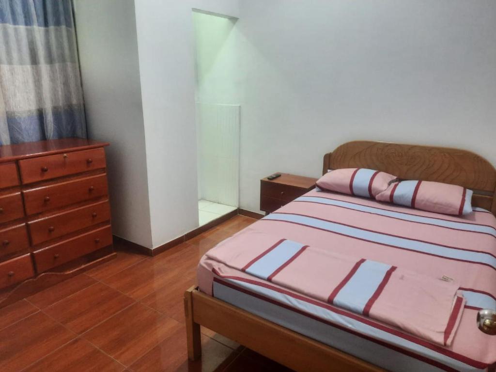 伊基托斯Casa Grande的一间卧室配有带梳妆台和床罩的床。