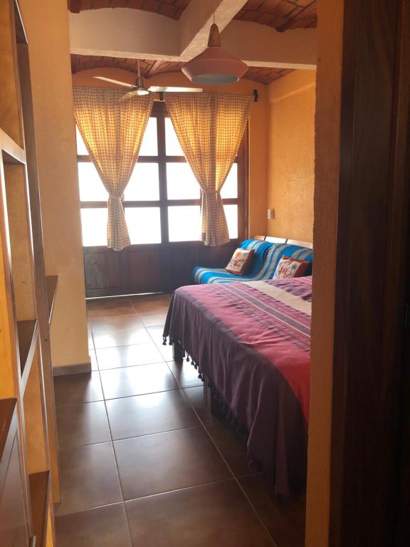 瓜亚比托斯Mountain View Lofts Guayabitos的一间卧室设有一张床和一个大窗户