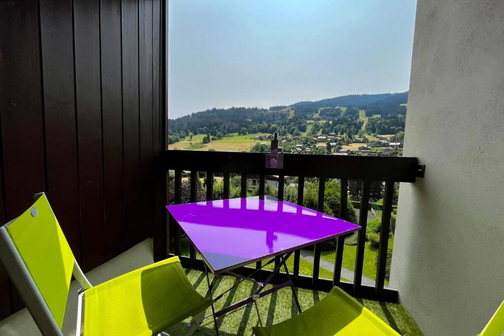 代米考迪亚Bright studio with view of Aiguille Verte的阳台配有紫色的桌椅