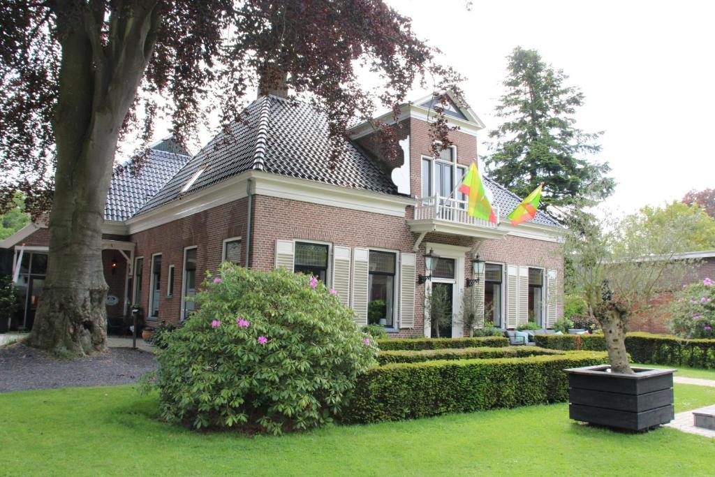 泽伊德拉伦Hotel B&B Hoeve de Vredenhof的两面旗帜的房子