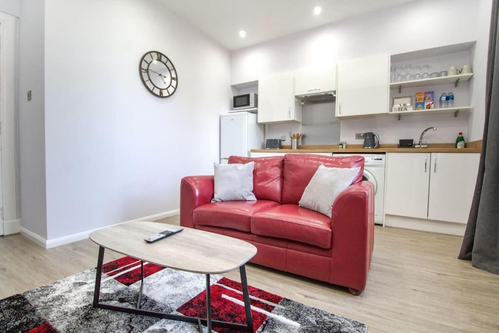 阿伯丁The Ojay's - Gustina Apartment的客厅配有红色的沙发和桌子