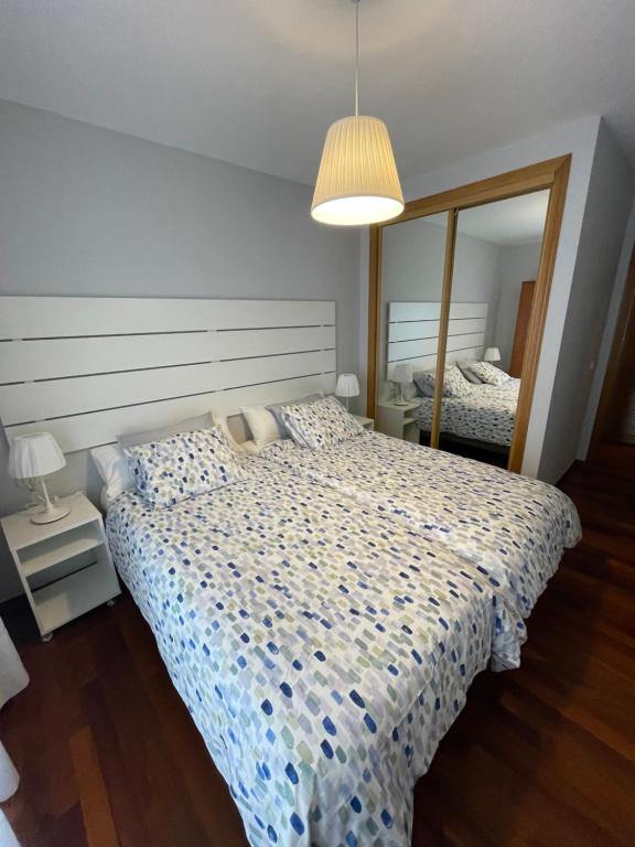 利亚内斯Apartamentos Los Cubos de Llanes 3的一间卧室配有一张床和一面大镜子