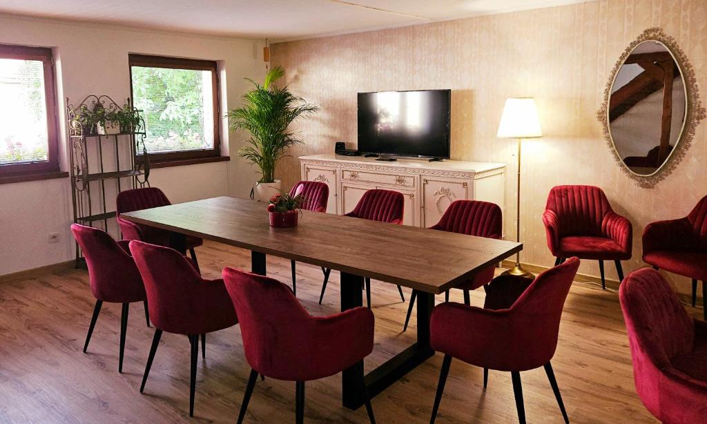 班斯卡 - 什佳夫尼察UV Apartmány的一间带桌子和红色椅子的用餐室