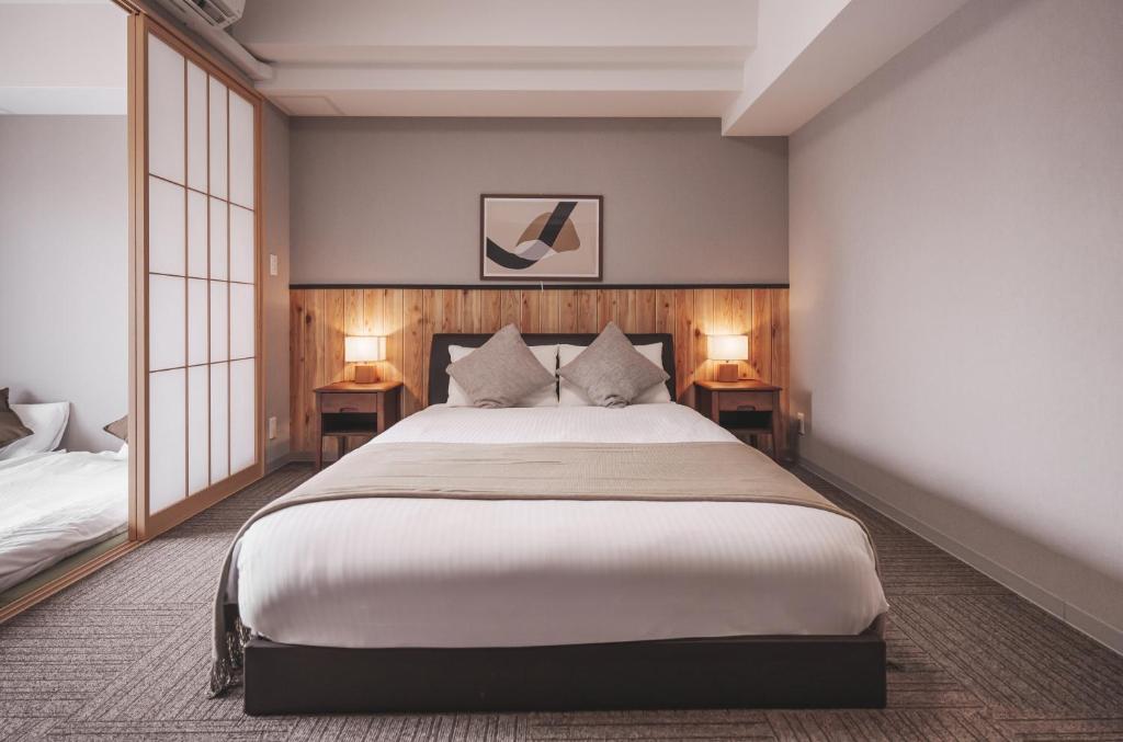 大阪川House道頓堀的一间卧室配有一张大床和两张台灯。