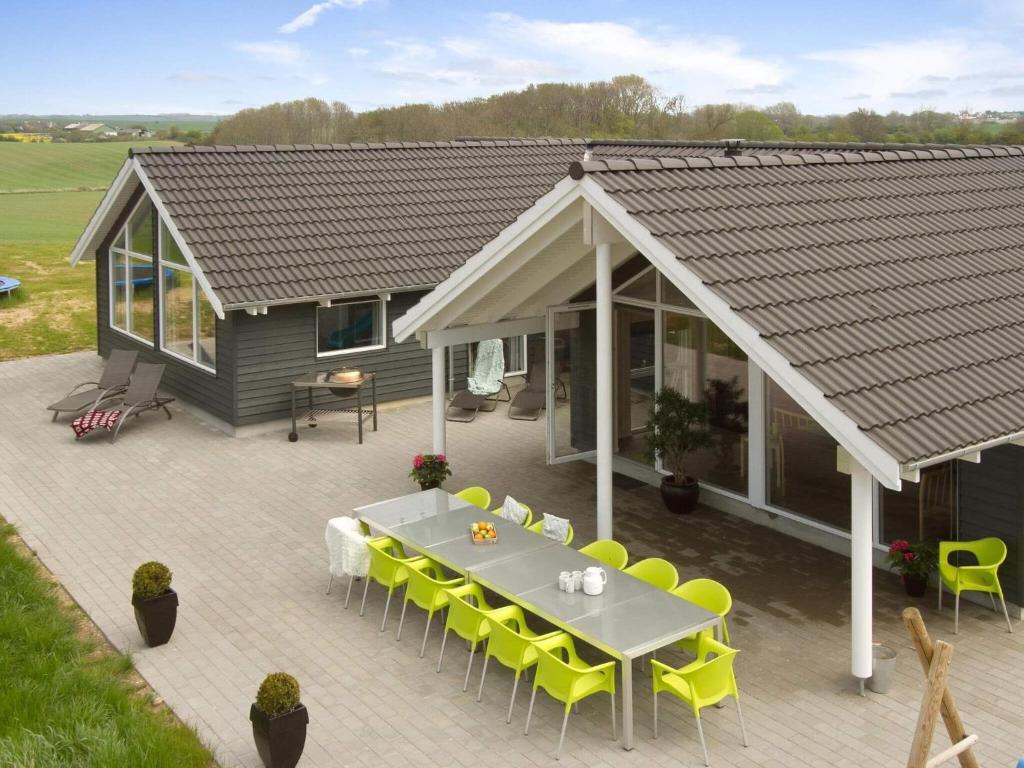 SønderbyHoliday home Sydals LXXXVI的享有房屋的顶部景致,配有桌子和黄色椅子