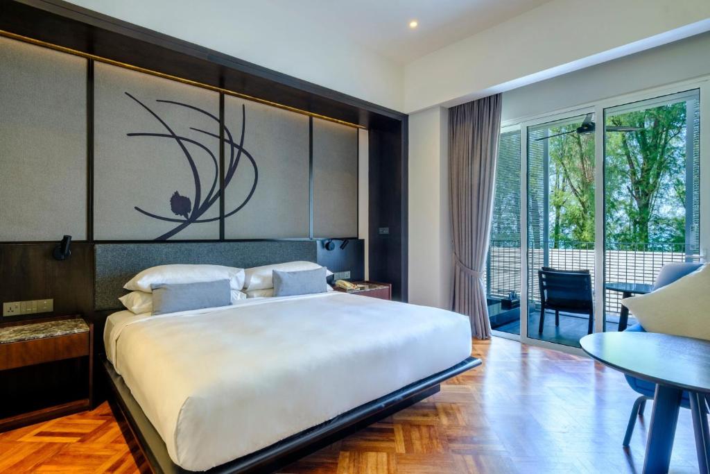 峇都丁宜孤松酒店的一间带一张白色大床的卧室和一个阳台