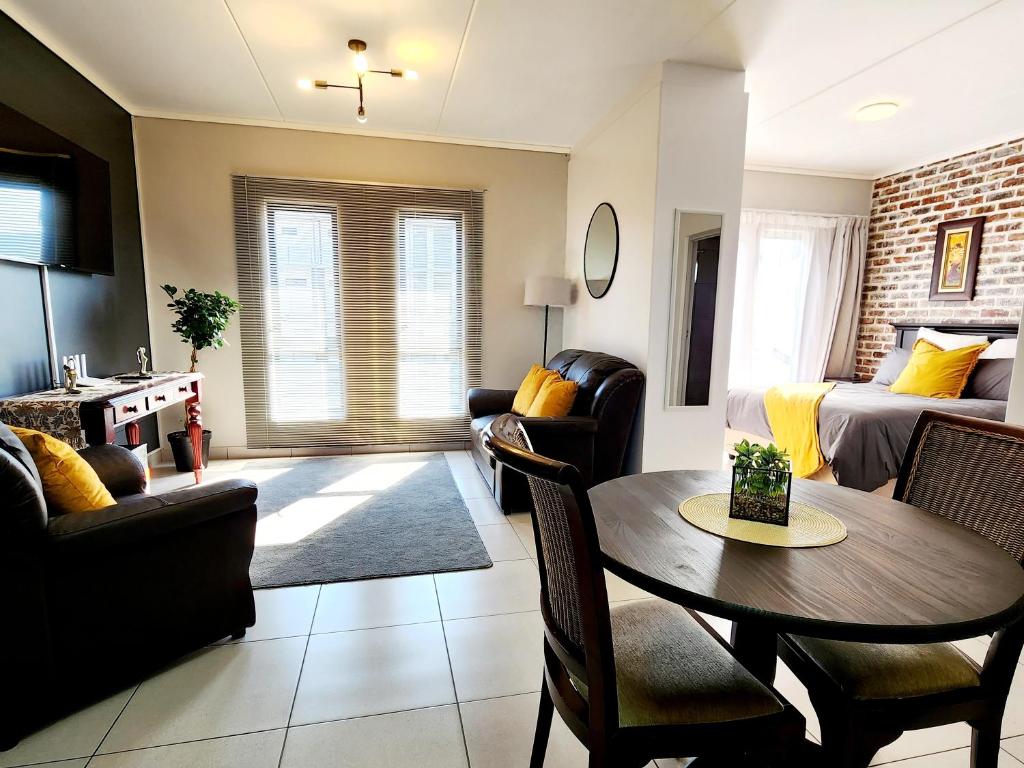 内尔斯普雷特Luxury Lowveld Apartment的客厅配有桌椅和沙发