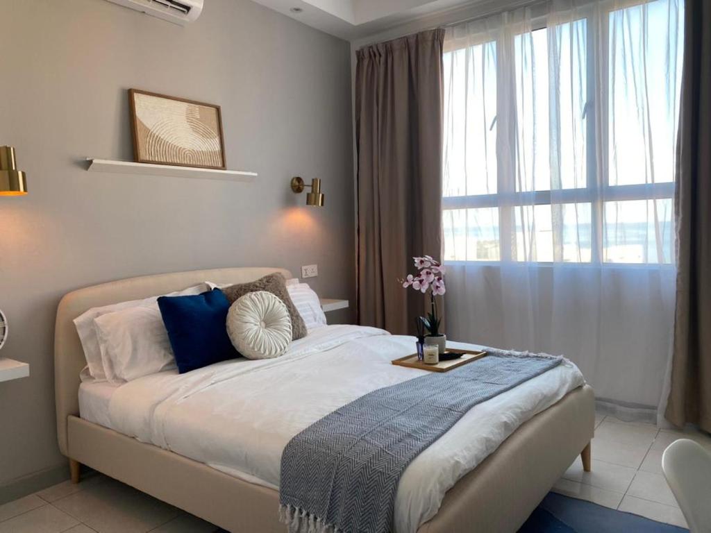 瓜拉丁加奴The Cotton Bleu Homestay的一间卧室设有一张大床和一个窗户。