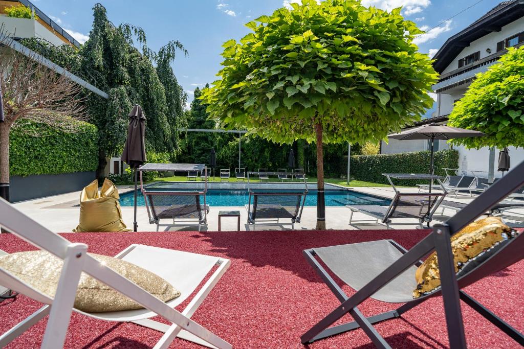 拉纳goldfinger + suites的庭院设有游泳池、椅子和一棵树
