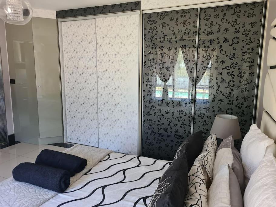 德班Umhlanga Guesthouse flat的一间卧室配有一张床和一个大衣柜
