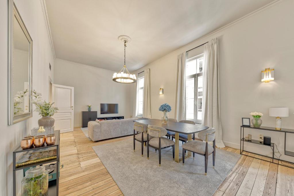布鲁塞尔Appartement dans l'hypercentre的客厅配有桌椅和沙发