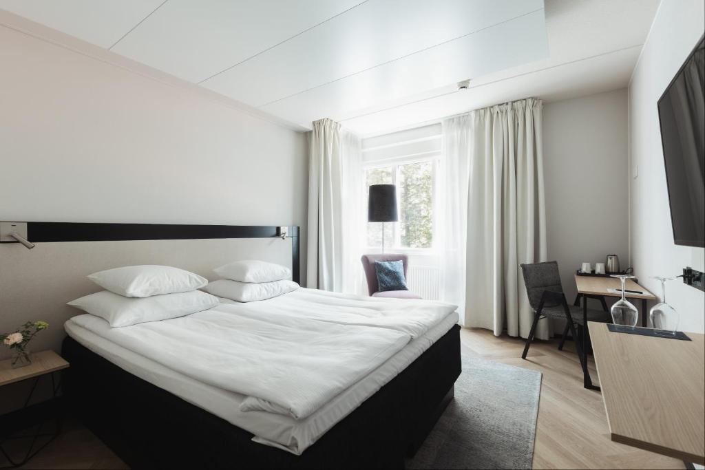 赫尔辛基GLO Hotel Art的卧室配有一张白色大床和一张书桌