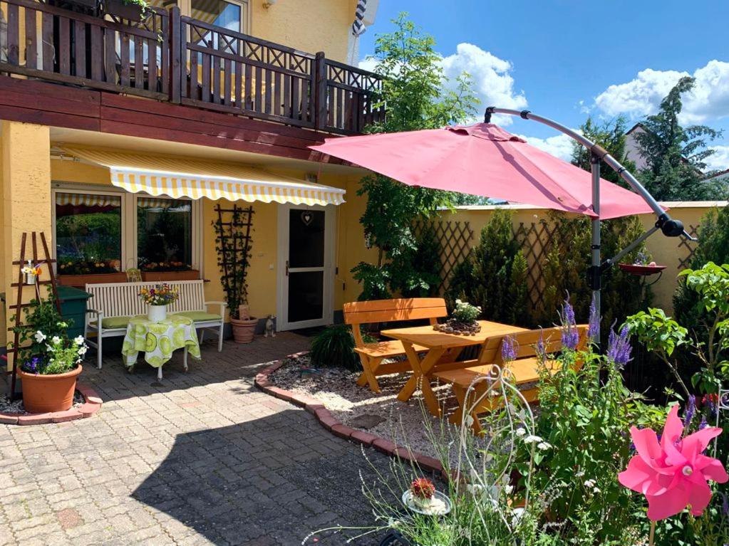 GermerodeFerienwohnung Mohnbrise的一个带桌子和粉红色遮阳伞的庭院