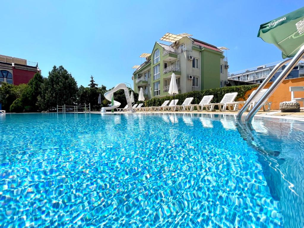 拉夫达Mint Family Hotel的一座蓝色海水和椅子的大型游泳池