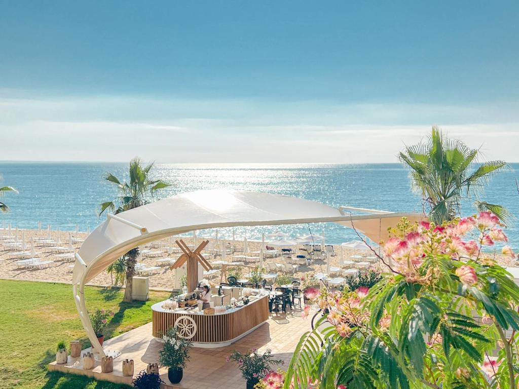 金沙Sentido Marea Hotel - 24 hours Ultra All inclusive & Private Beach的海滩上的餐厅,以大海为背景