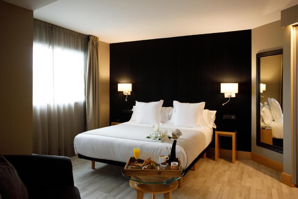 拉科鲁尼亚广场酒店的酒店客房配有一张带白色枕头的大床