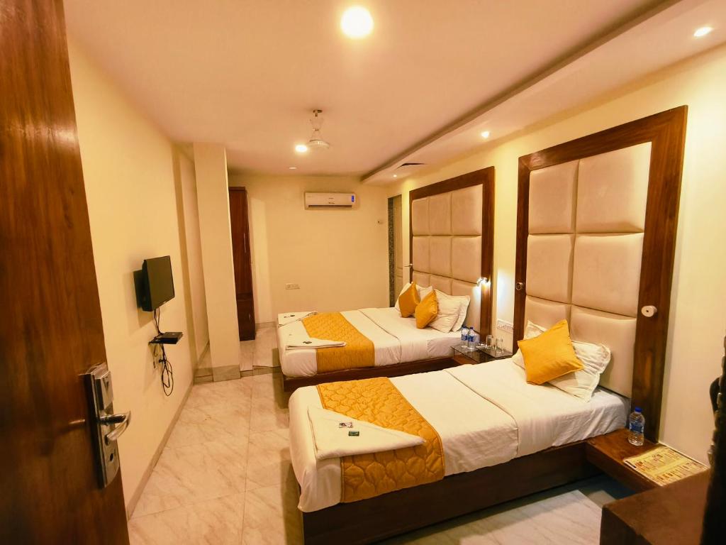 孟买Apex Hotel的酒店客房设有两张床和电视。