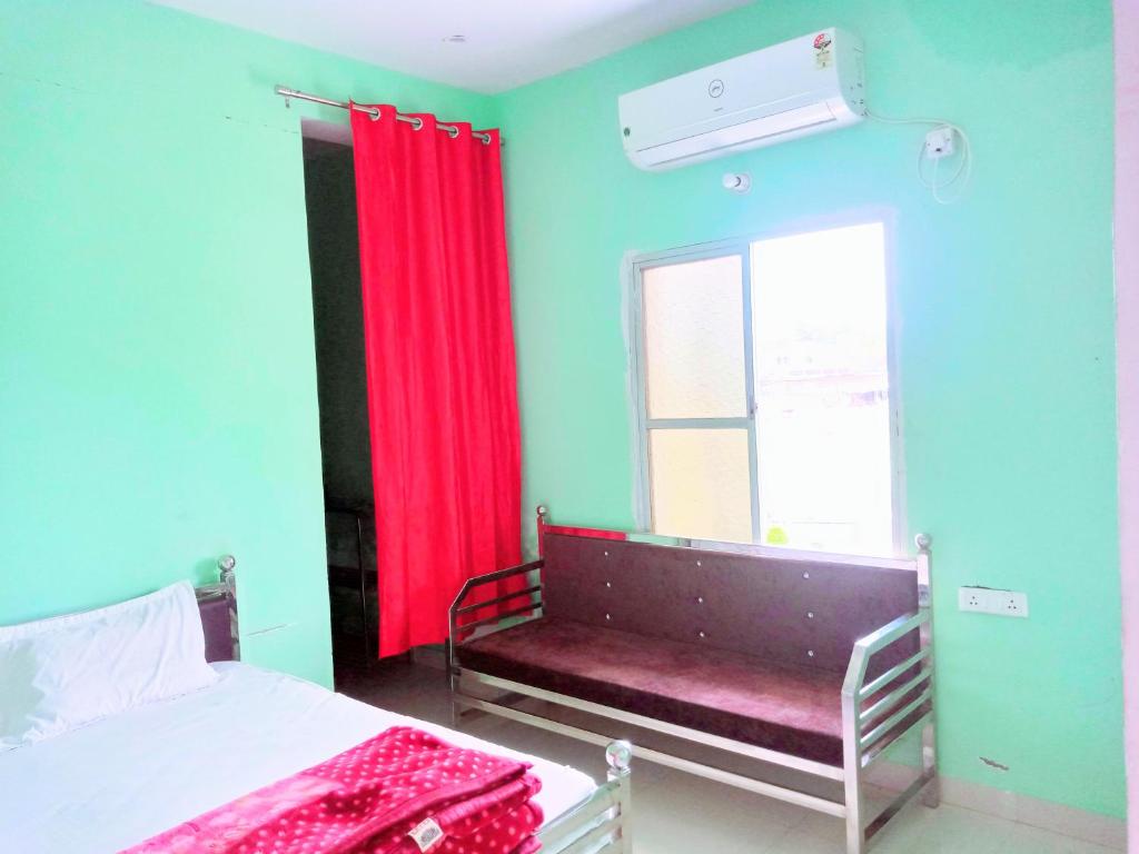 Sītāpur MūāfiHotel Parvati Residency的一间卧室配有一张床和一个带红色窗帘的窗户