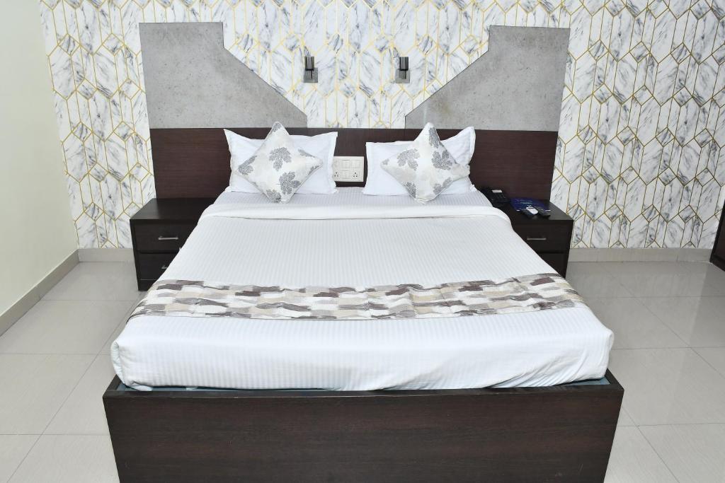 巴特那PARK PRIDE INN的卧室配有一张带白色床单和枕头的大床。