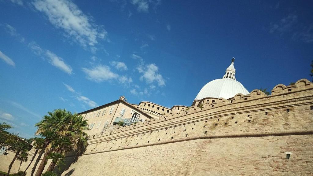 洛雷托Hotel Madonna di Loreto的墙上有圆顶的建筑
