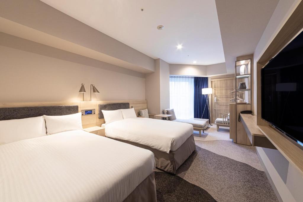 名古屋Hotel Keihan Nagoya的酒店客房设有两张床和一台平面电视。
