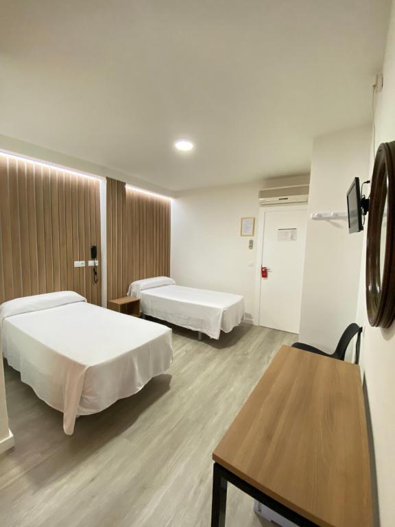阿尔姆尼卡维多利亚中心酒店的一间医院间,配有两张床和一张桌子