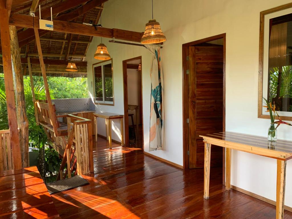 卢纳将军城Wayans Siargao的客厅铺有木地板,配有木桌。