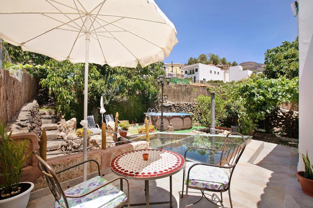比拉夫洛尔Casa Tajinaste的庭院配有遮阳伞和桌椅。