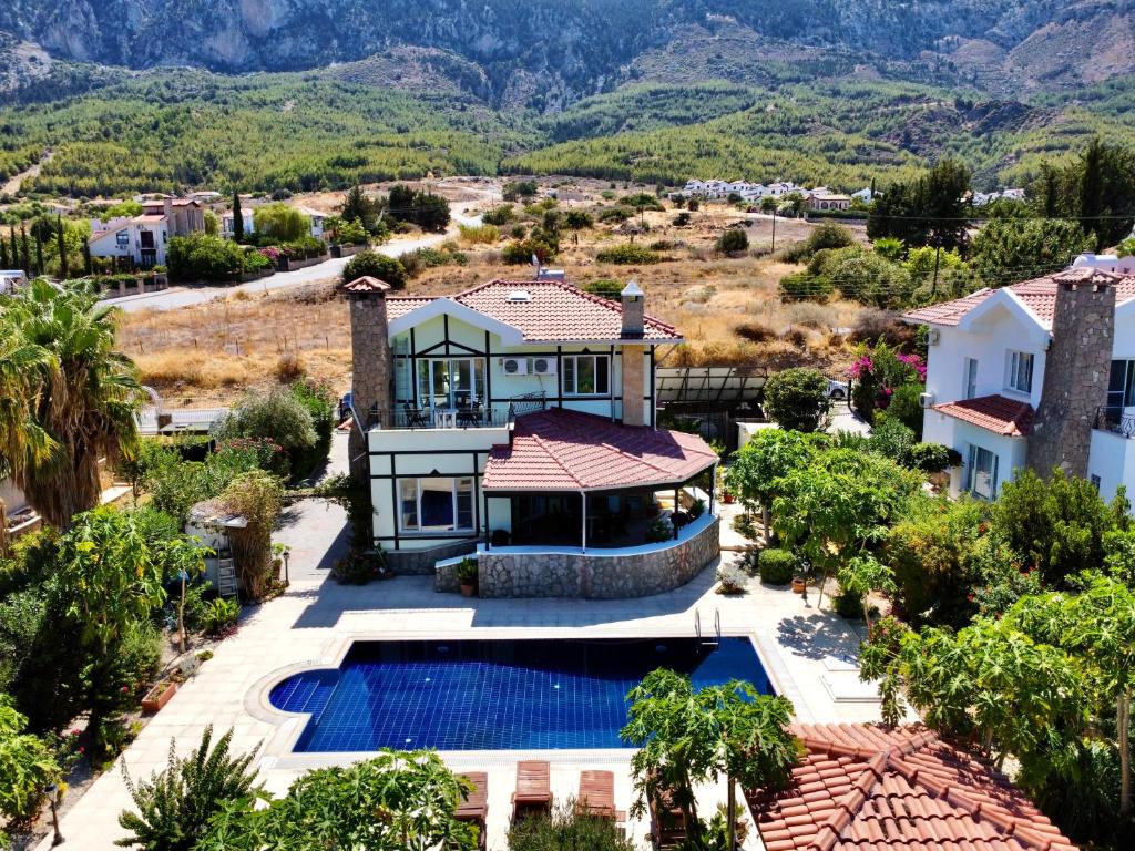 凯里尼亚4 Bedroom Deluxe Villa with Mountain and Sea View的享有带游泳池的房屋的空中景致