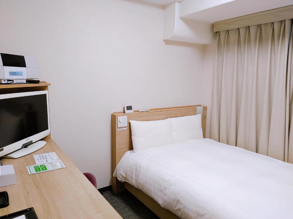 松江市多美迎EXPRESS松江酒店的酒店客房,配有床和电视