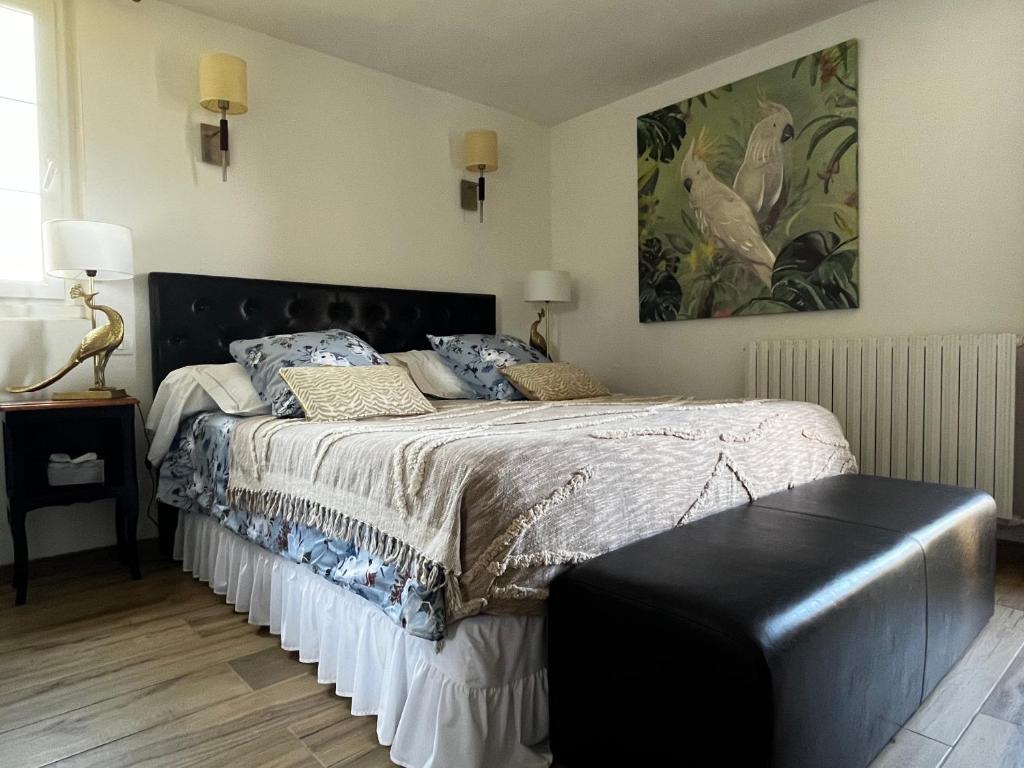 PuylaroqueVILLA LES HAUTS VALLONS的一间卧室配有一张大床和黑色床头板