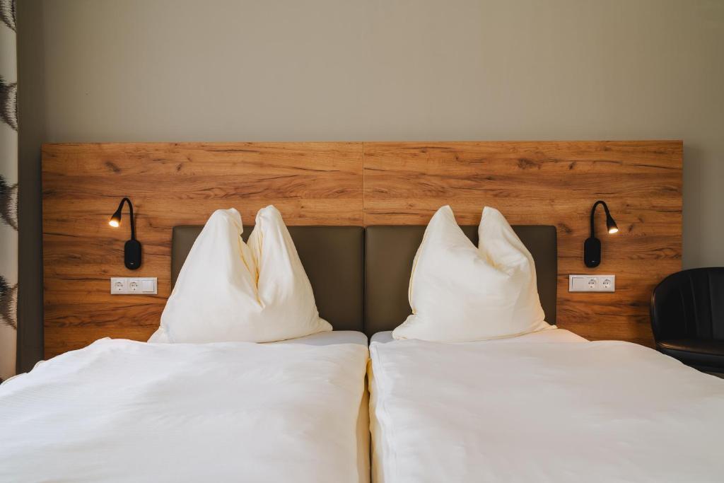 阿诺尔德施泰因Die Pension Galle的两张带白色枕头的床,彼此相邻