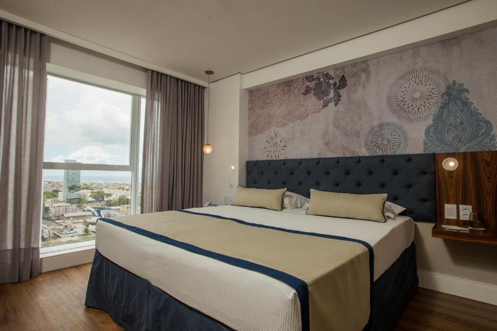 累西腓Hotel Luzeiros Recife的一间卧室设有一张大床和一个大窗户