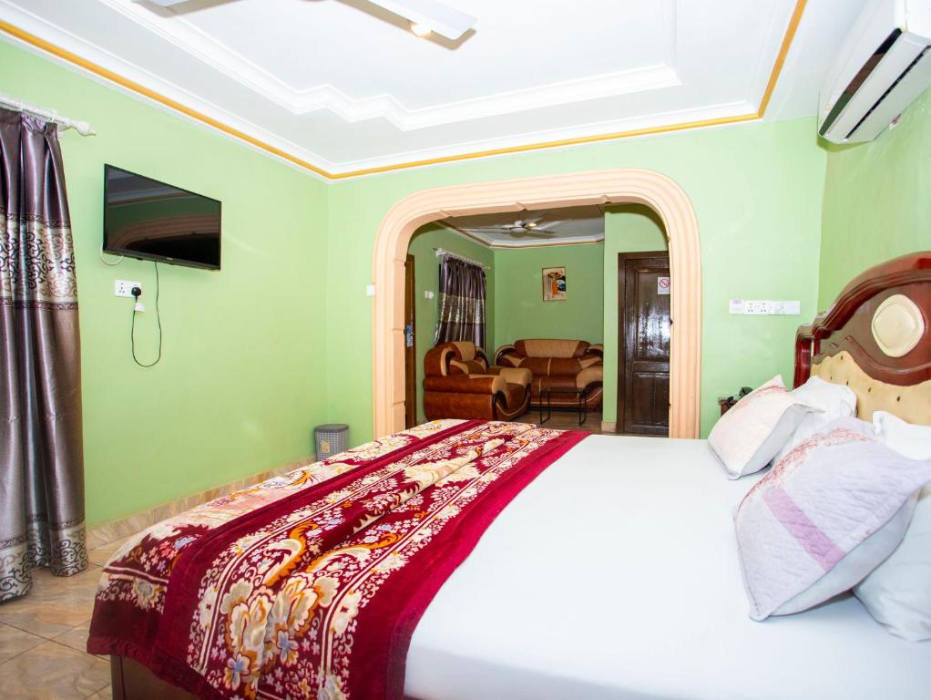 库马西Glory Hills Hotel的一间卧室设有一张床和一间客厅。