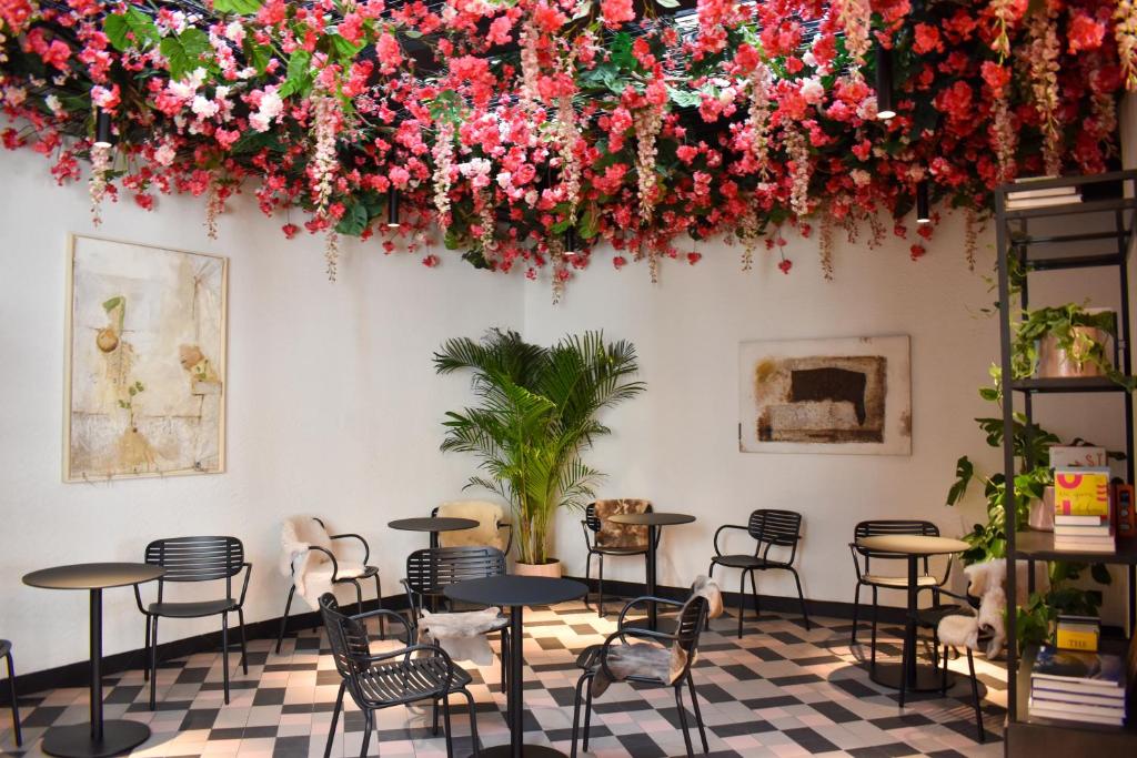 奥斯坦德Rosa Hotel的配有桌椅和鲜花的房间