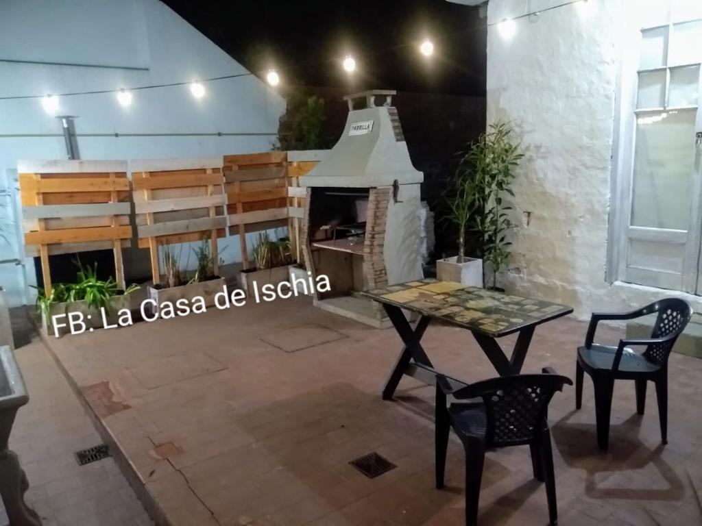 马德普拉塔La Casa de Ischia的客房设有桌椅和壁炉。