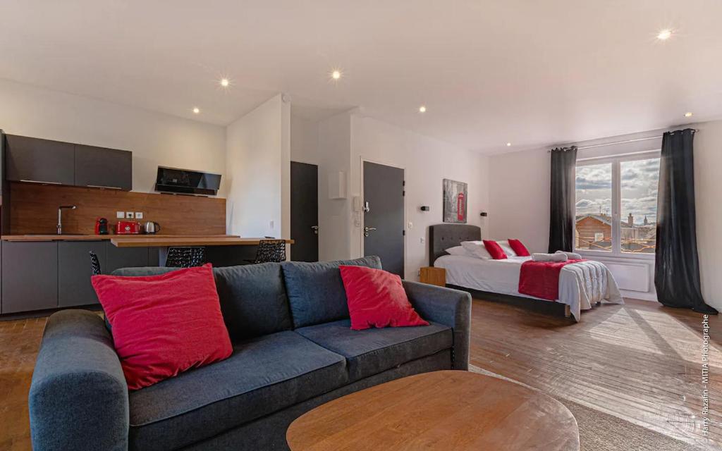 里摩日Les suites locarno的客厅配有沙发和1张床