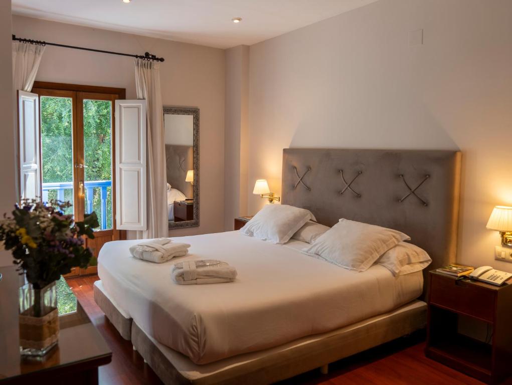 哈兰迪雅·德·拉·维尔奧地利的唐胡安乡村酒店及Spa的一间卧室配有一张大床和两条毛巾